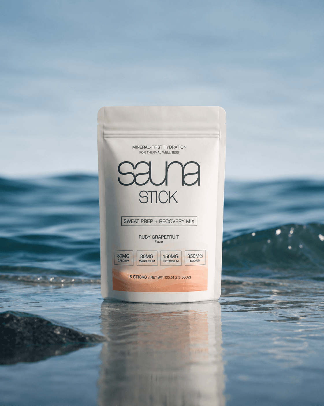 Sauna Stick Ruby Grapefruit pouch standing in ocean water