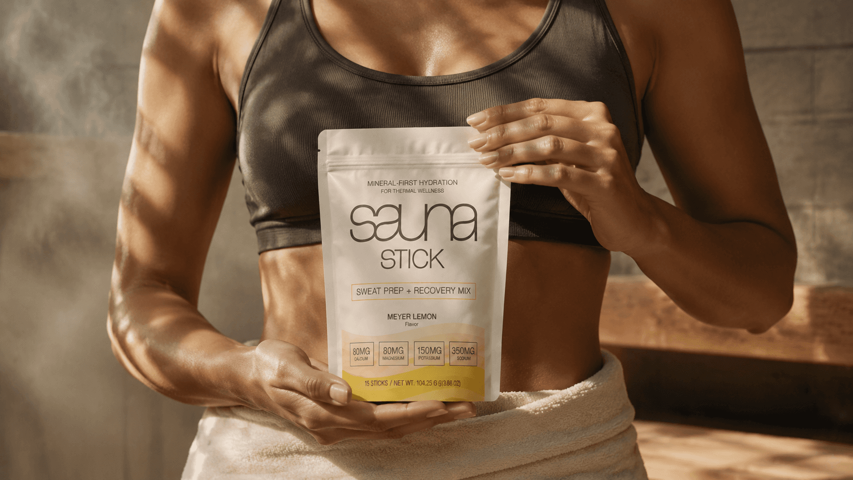 Athlete holding a Sauna Stick Meyer Lemon pouch